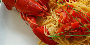 Homard Dégustant ses Spaghetti aux Dés de Tomates