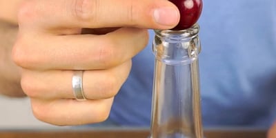 Il place une Cerise sur une Bouteille