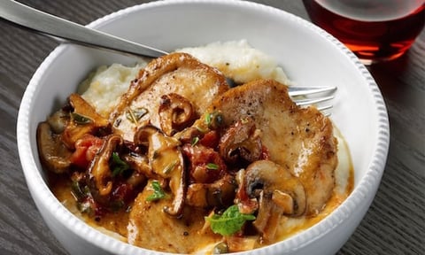POULET AUX CHAMPIGNONS SAUVAGES, AUX TOMATES ET AUX CÂPRES SUR DU GRUAU CRÉMEUX À L’AIL