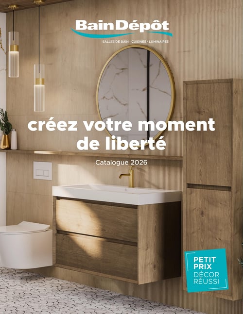 Circulaire Bain Dépôt - Page 1. La page de couverture présente une salle de bain moderne et chaleureuse. Au centre, un meuble-lavabo en bois clair avec deux tiroirs, surmonté d'un lavabo blanc et d'un robinet doré. Au-dessus, un miroir rond encadré de doré reflète un mur texturé. À gauche, une toilette suspendue est visible. À droite, une haute armoire de rangement en bois assorti complète l'ensemble. Deux luminaires suspendus cylindriques éclairent la scène. Le slogan principal est "créez votre moment de liberté", avec la mention "Catalogue 2026". En bas à droite, une étiquette turquoise indique "Petit prix décor réussi".